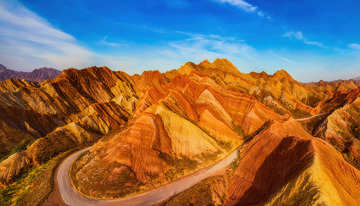 蓝天映耀下公路穿梭斑斓丹霞