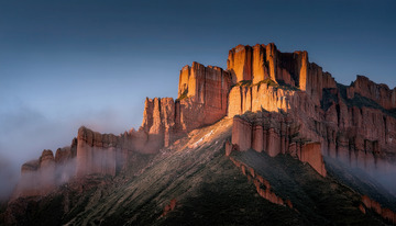 晨雾中被光照亮的赤色丹霞岩壁