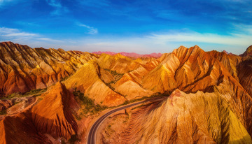 公路蜿蜒于五彩斑斓的丹霞地貌