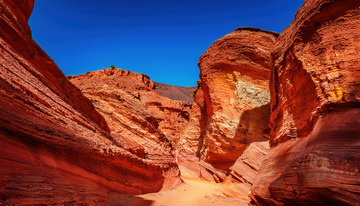 蓝天下赤红嶙峋的壮美丹霞峡谷