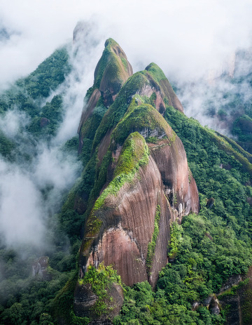 云雾中植被覆盖的奇特连绵山峰