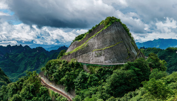 青山间绕岩穿行的蜿蜒绿色公路