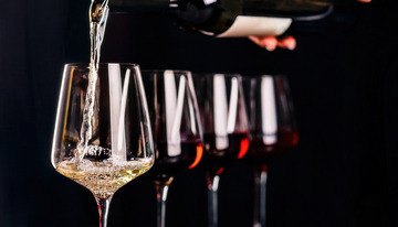 往高脚杯倒白葡萄酒的对比场景