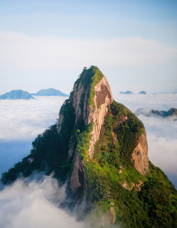 云海之上绿意盎然的孤耸山峰