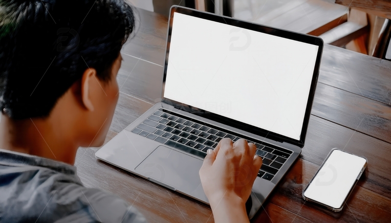 高清大图下载【趣麦麦图】男子于木桌前操作电脑与手机