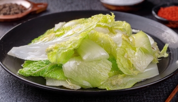 黑盘里摆放着清炒大白菜