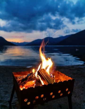 湖畔暮色中燃烧的温暖篝火