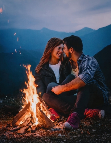 山景中篝火旁情侣甜蜜相伴时刻