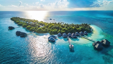 马尔代夫阳光洒落的海岛水上屋风光