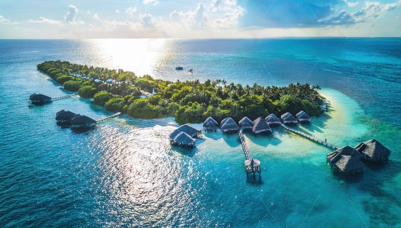 马尔代夫阳光洒落的海岛水上屋风光