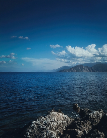 蓝天碧海间的嶙峋礁石海岸景致