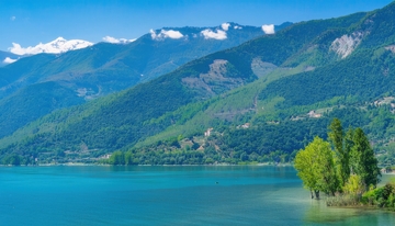 雪山下翠绿山峦环绕的碧湖风光