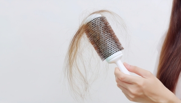 手持梳子梳理并带出掉落头发