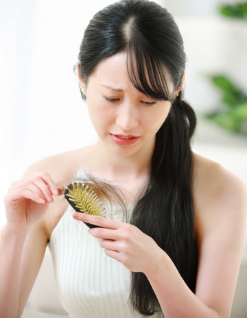 女性手持梳子检查头发状况