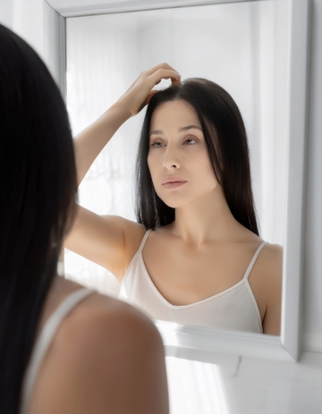 女性镜前手扶发缝查看情况