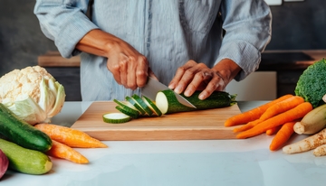 人在厨房切菜的场景