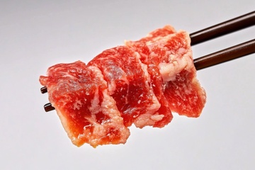 筷子挑起生猪肉片