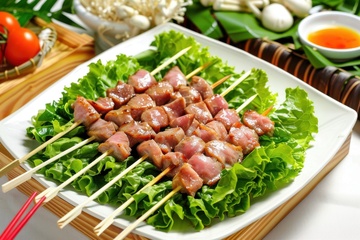一盘烤肉串垫着生菜