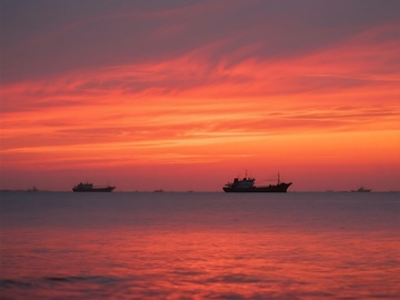 海上日落时的船只剪影画面