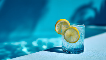 蓝色泳池背景柠檬切片冰饮