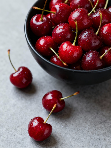 樱桃满黑碗带水珠木质背景更诱人