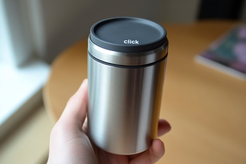 一只手拿着不锈钢杯子