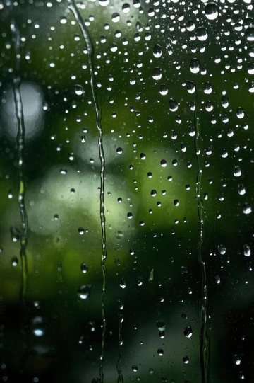 玻璃上的雨滴与绿色背景