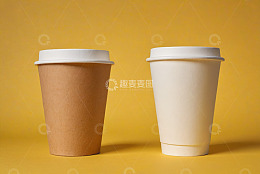 黄色背景下两个一次性纸杯