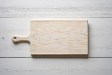 浅色木质砧板置于白色木桌