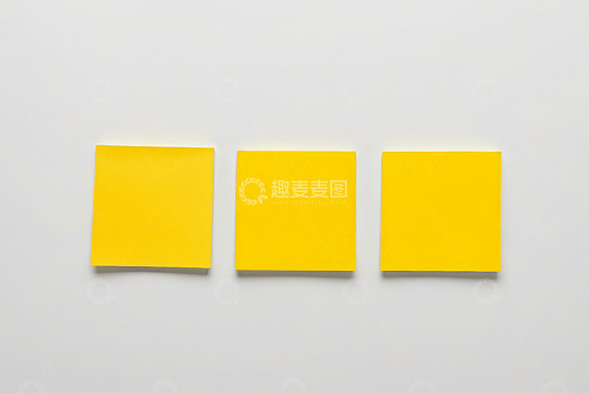 三张黄色便签纸摆放在白色背景