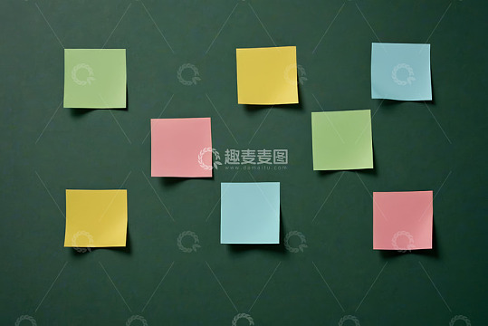 彩色便签纸排列在绿色背景上