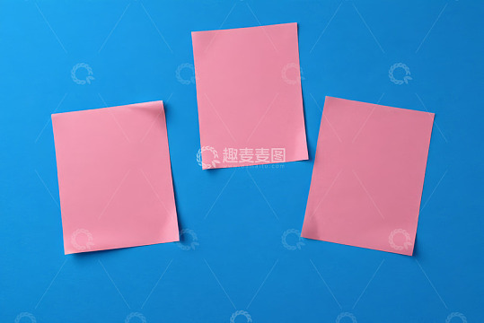 蓝色背景上的三张粉色空白纸