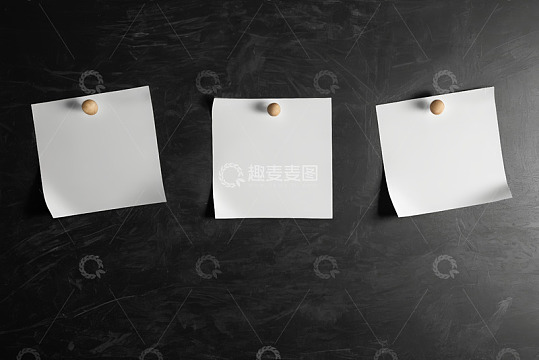 黑色背景上用图钉固定的白纸