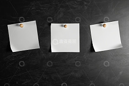 黑色背景上用图钉固定的白纸