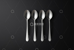 黑色背景下的四把金属勺子