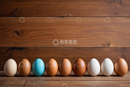 木桌上排列的多彩鸡蛋
