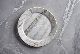 大理石背景上的白色花纹餐盘