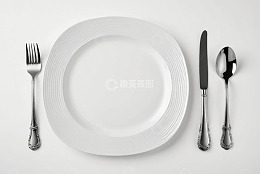 白色餐盘与银质餐具摆拍