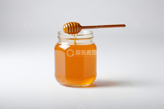 玻璃罐蜂蜜与蜂蜜棒特写