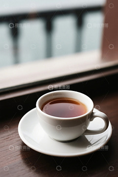 窗边白色杯碟中的茶饮
