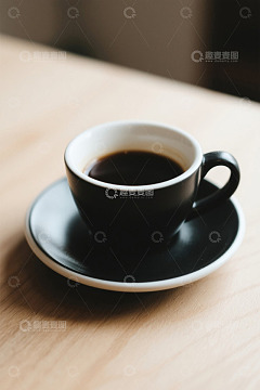 木桌上的黑色咖啡杯与咖啡