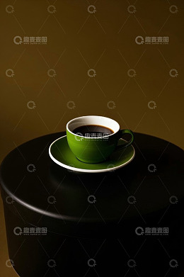 黑色圆桌上的绿色咖啡杯