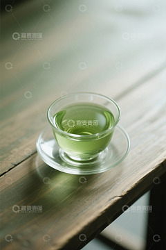 木桌上的玻璃茶杯装着绿茶