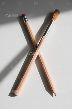 白色背景上交叉的铅笔与画笔