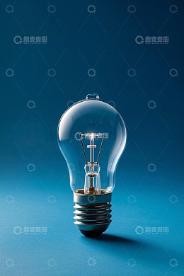 蓝色背景下发光的白炽灯泡