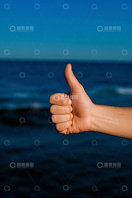 海边竖大拇指的手部特写