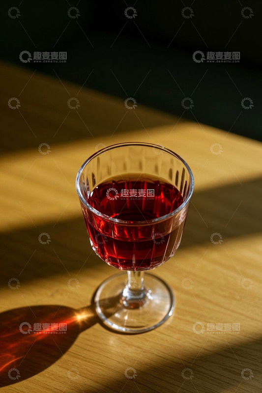 木桌上盛有红色液体的玻璃杯