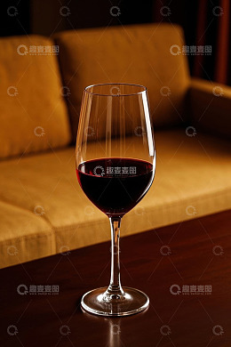 沙发旁桌上的一杯红葡萄酒