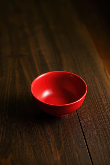 红色碗置于木质桌面上