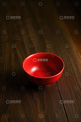 红色碗置于木质桌面上
